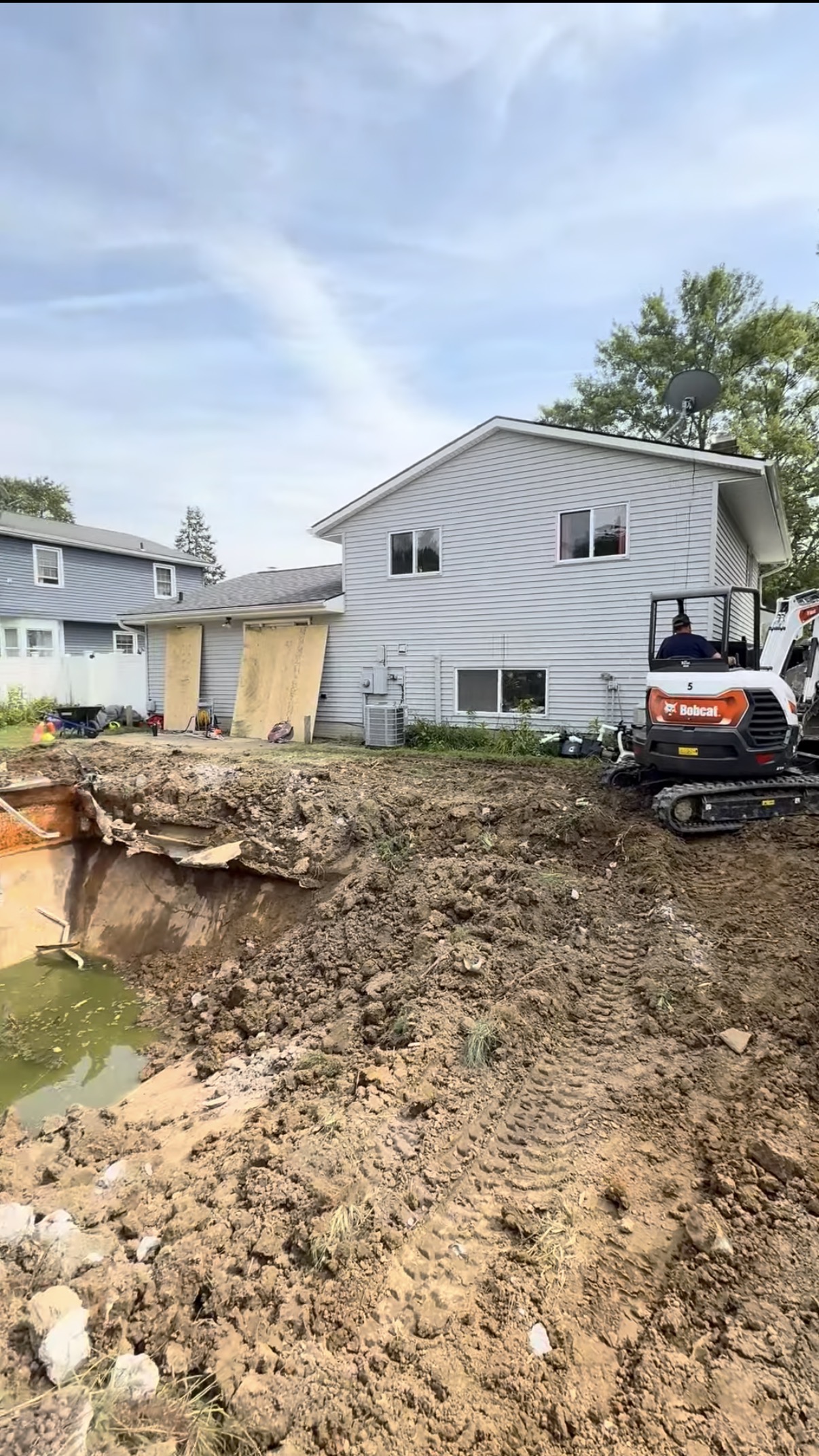 A mini excavator working beside a home during site preparation
