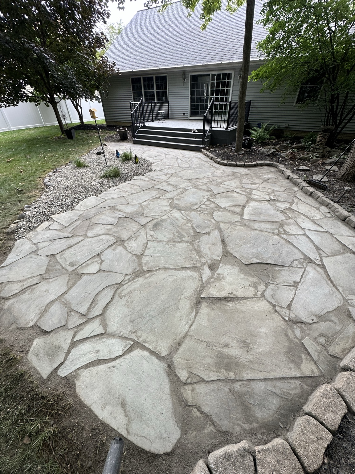 Flagstone patio with stone edging and a gravel planting bed